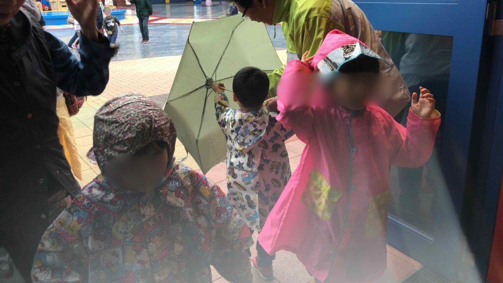 雨の日にレインコートを着てレゴランドを楽しむ子どもたち
