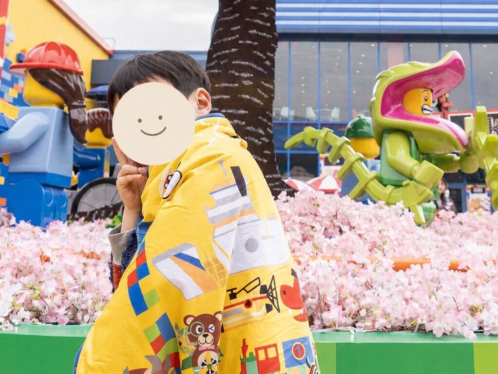 レゴランドのキャラクター柄ブランケットを羽織った子ども