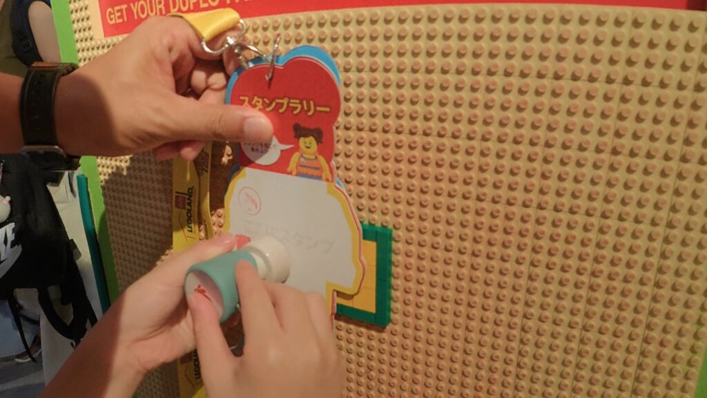 アクティビティパックのカードに館内のスタンプを押す手元